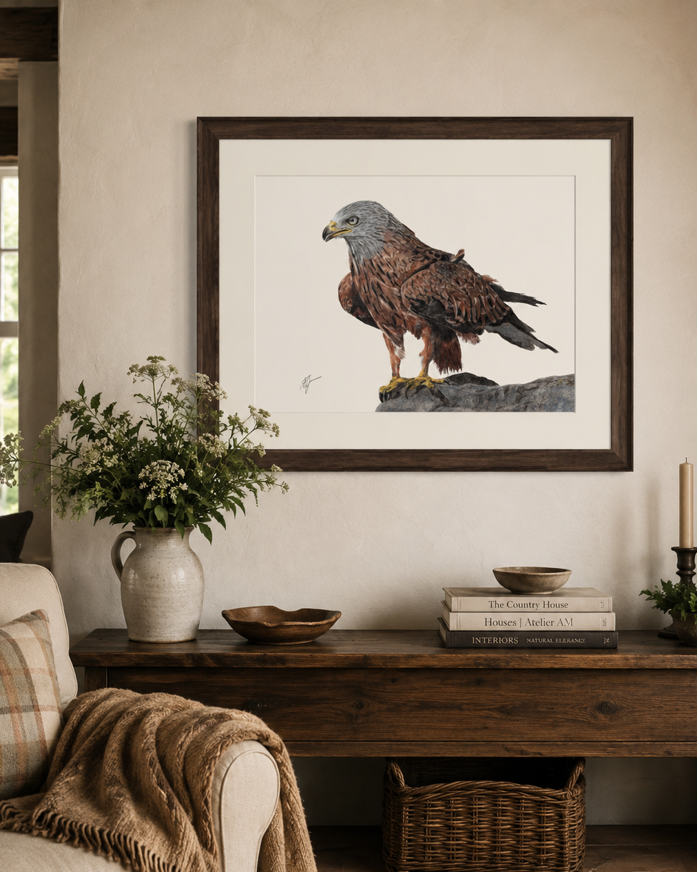 A framed art print of a brown hawk hanging on a beige wall above a rustic wooden console table in a styled living room setting.