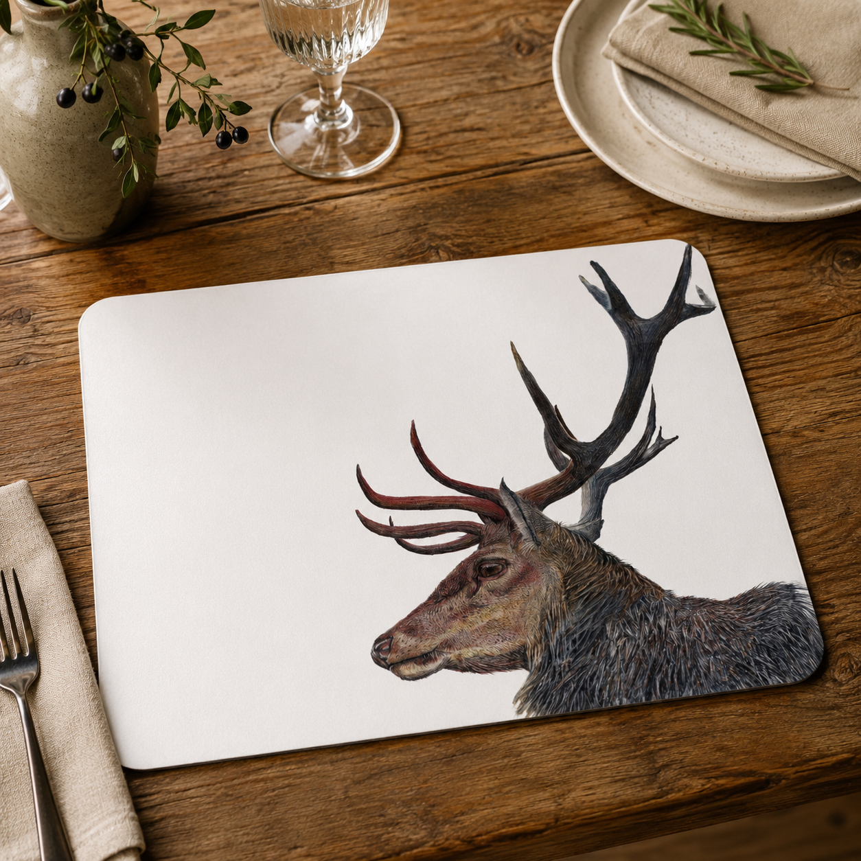 Placemat with deer design on a wooden table with cutlery and plates.