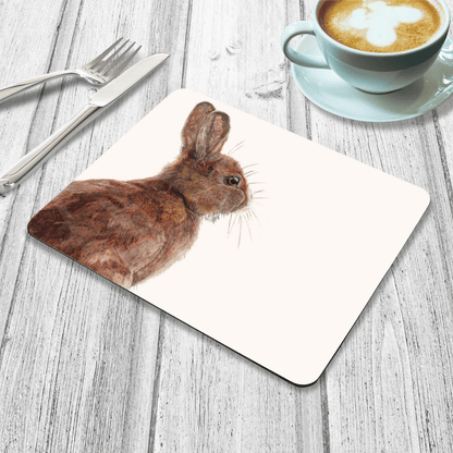 Placemat with a rabbit design on a wooden table with a cup of coffee.