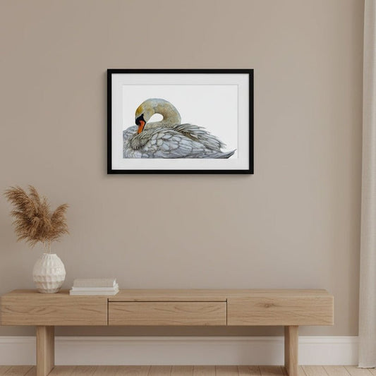 Framed artwork of a swan on a wall above a wooden console table.