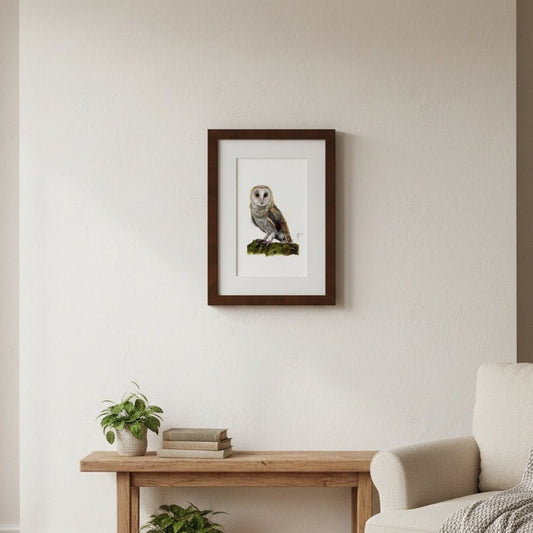 Living room with a framed picture of an owl on the wall, a wooden coffee table with plants and books, and a beige armchair with a blanket.
